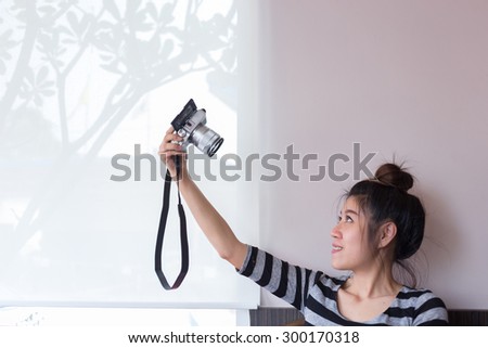 asian woman take a photo selfie with mirrorless digital camera