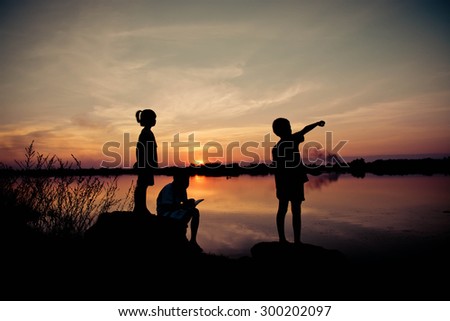 silhouette children playing happy time at sunset 
