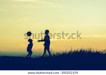 boys playing football at sunset. silhouette concept