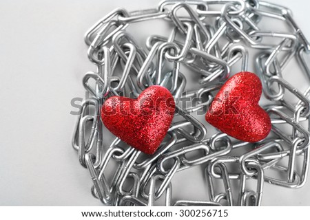 Two red hearts with metal chain, closeup