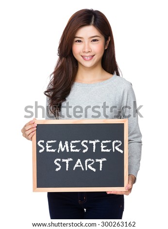 School girl hold with chalkboard and showing phrase of semester start