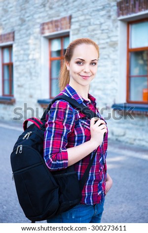 smiling teenage student girl with backpack standing on street