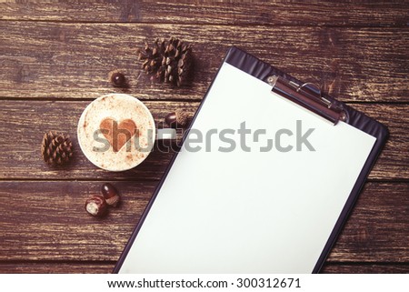 Cup of coffee and tablet on wooden table.