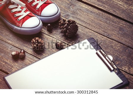 Pine cones and business tablet on wooden table.