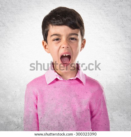 Child shouting over grey background