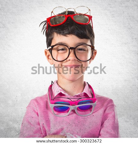 Happy boy with many glasses over grey background