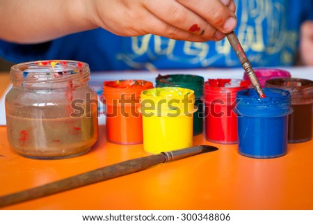 Several cans of paint on the children's table while drawing. Selective focus.