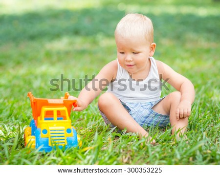 Cute baby is playing toy car