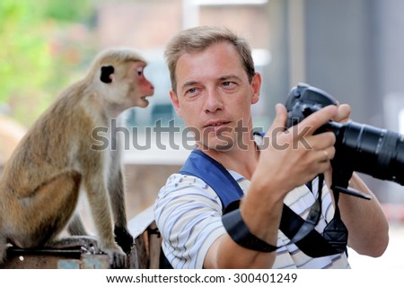 Photographer shows a monkey by her photo shoot