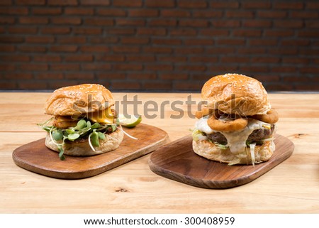 Burger series : Shrimp burger and squid ring burger on wooden plate with brick wall background