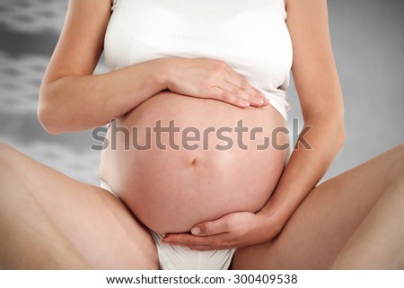 blurred background of gray wall with shadow and pregnancy 