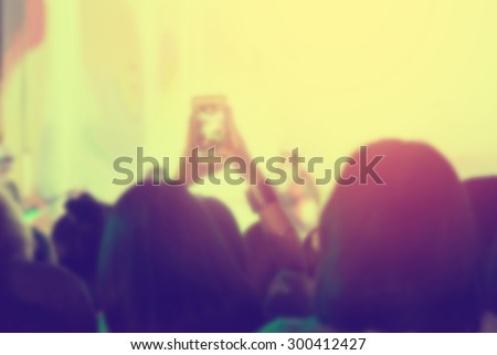 crowd of Audience enjoying music in concert on stage with smart phones