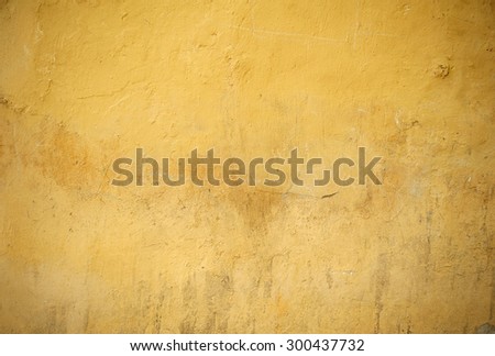 Texture of old rustic wall covered with yellow stucco
