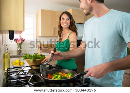 Playful lifestyle cooking at home man and woman flirting and in love  Royalty-Free Stock Photo #300448196