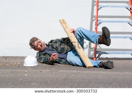 Injured construction worker who just fell from a ladder on a construction job Royalty-Free Stock Photo #300503732
