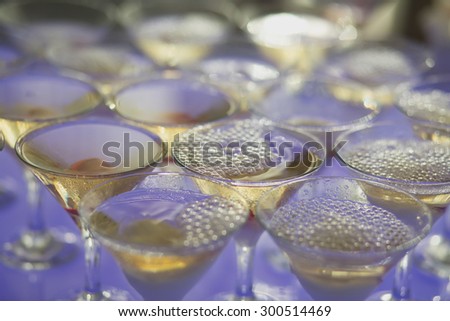 Beautiful row line of different colored alcohol cocktails with mint on a open air party, tequila, martini, vodka, and others on decorated catering bouquet table on open air event, picture 