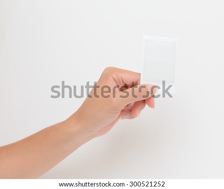 One instant photo in hand isolated on white background