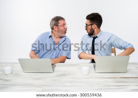 The two colleagues working together at office on white  background. They surprised looking at each other