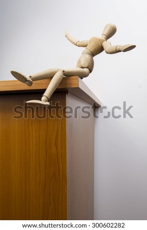 Wooden dummy falls from a table