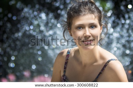 Young woman's portrait near fountain in summer