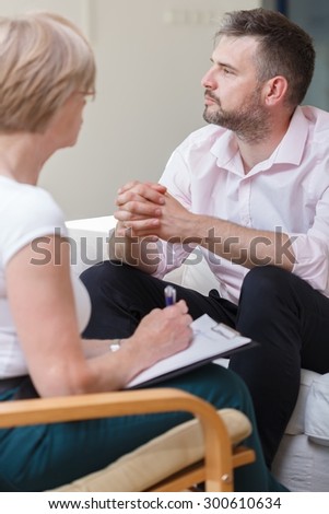 Photo of stressed male during session with female psychiatrist