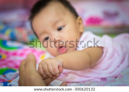 Cute newborn baby hand holding mother's finger.