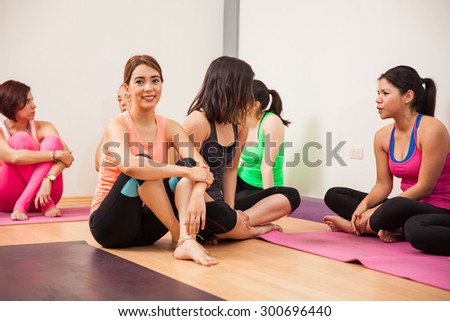 Cute girl sitting and socializing with the group after their yoga class