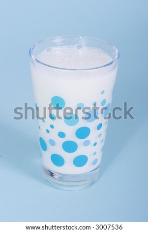 a glass on milk on blue background
