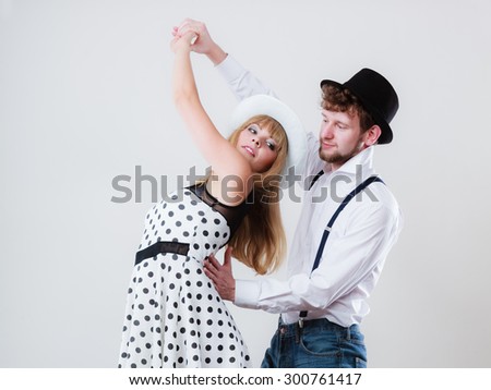 Young happy couple retro style dancing studio shot on gray