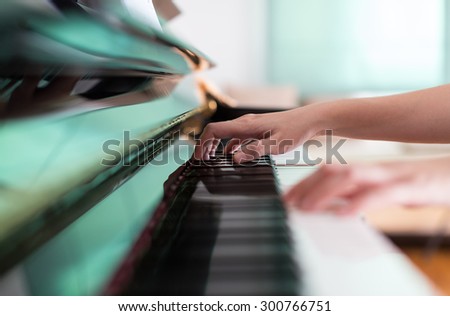 Lady playing piano with selective focus and shallow depth of field.