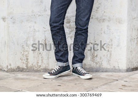 Regular Fit Straight Leg Jeans and Retro Canvas High Top Sneakers on Plaster wall background, selective focus (detailed close-up shot) Royalty-Free Stock Photo #300769469