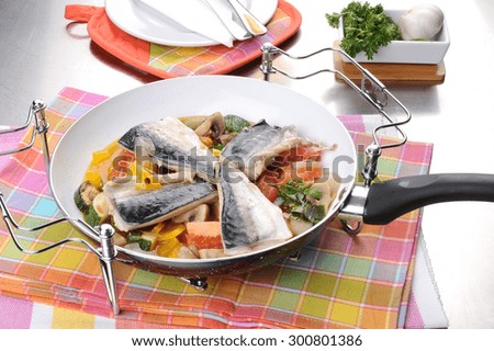 Fillet of sea bass with vegetables in a pan