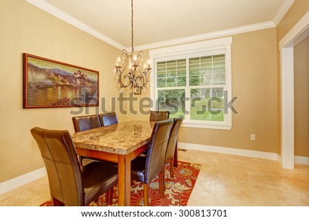 Elegant dinning room with marble top table and a chandelier.