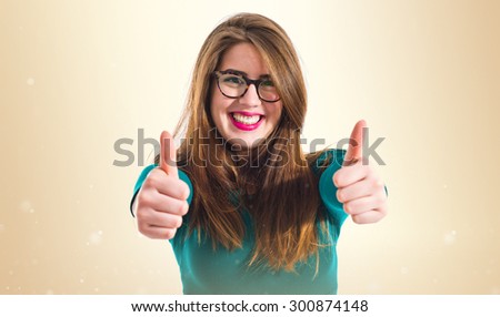 Girl with thumb up over ocher background