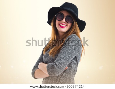 Happy girl with her arms crossed over ocher background