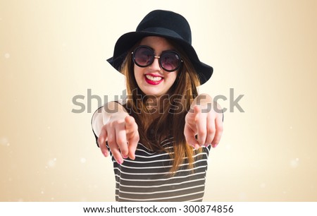 Girl pointing to the front over ocher background