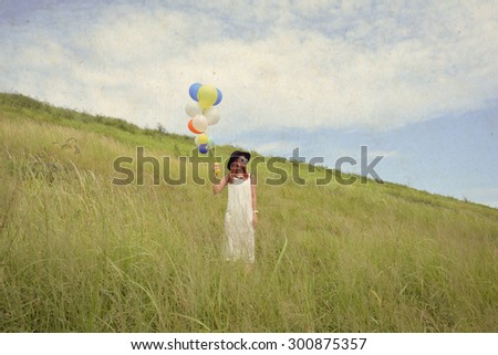 young beautiful girl with balloons in the field,vintage effect filter style pictures