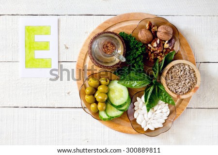 Foods containing vitamin E: walnuts, sunflower seeds, sunflower oil, herbs, pumpkin seeds, olives, cucumbers Royalty-Free Stock Photo #300889811