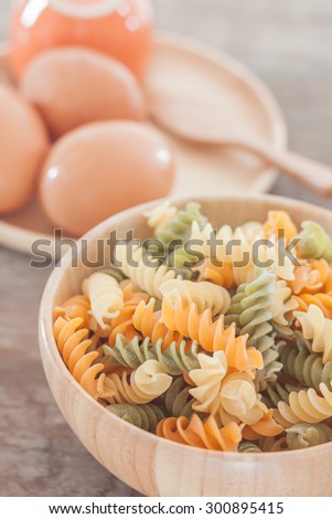 Fusili pasta in wooden plate with eggs, stock photo