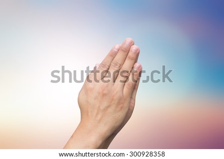 Hands pray on blurred of twilight sky backgrounds for religious concept