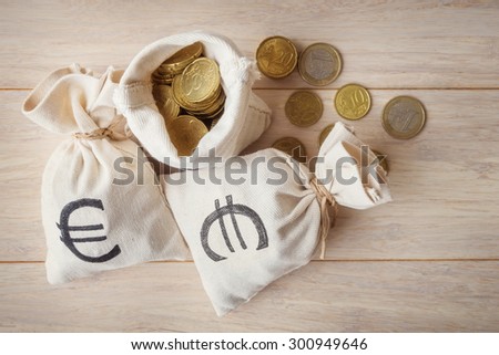 Euro coins in money bags, top view