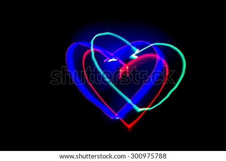 Light of painting the heart shape on black background.