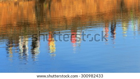 close-up reflection in the water silhouettes of people walking on a stone embankment