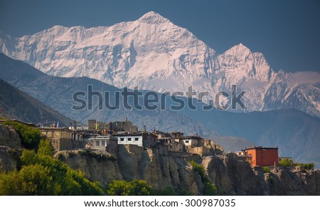 Rural life in front of Incredible Himalayas.  Nepal, ACAP, Upper Mustang, Kagbeni village (2,810 m) and Nilgiri North (7,061 m) Royalty-Free Stock Photo #300987035