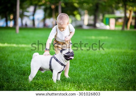 a boy and a pug in park