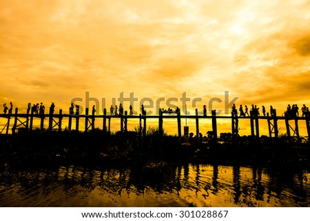 Silhouetted people on U Bein bridge at sunset Mandalay, Myanmar