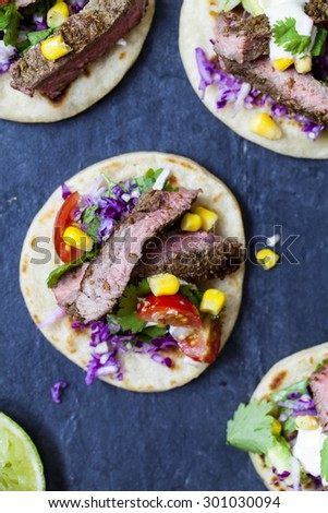 Beef steak tortilla with avocado, sweet corn and tomato salsa and red cabbage coleslaw