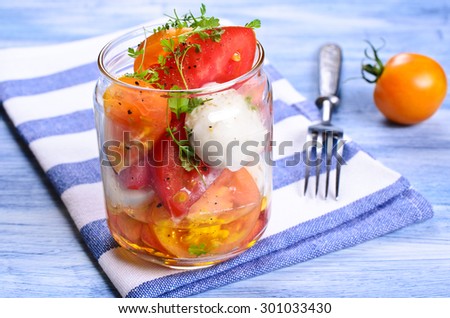 Salad of tomatoes and mozzarella with watercress in a glass container. Selective focus. 