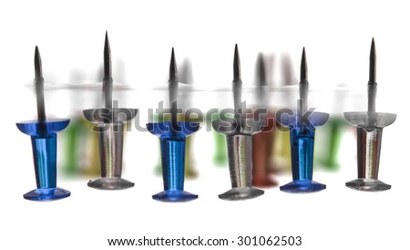 Stationery Push Pin photo illustration. Blue, green, red and yellow push pins set in various configurations and situations.