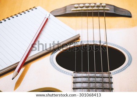Notebook and pencil with guitar for writing music , Concept of music
